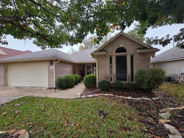 a front view of a house with yard and green space