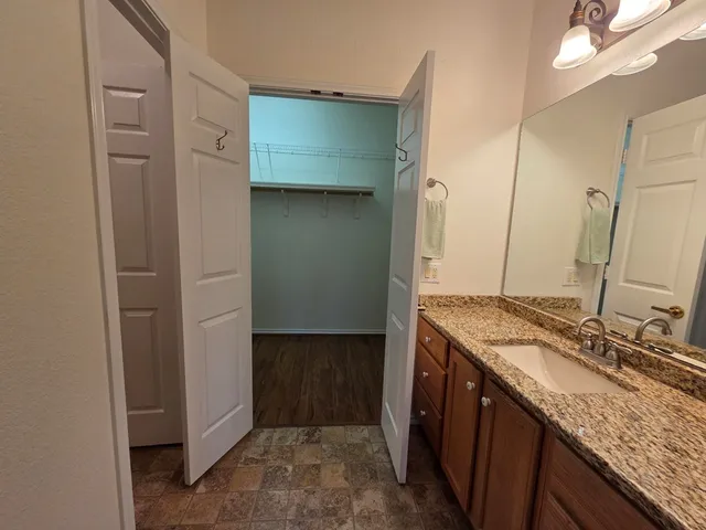 a bathroom with a granite countertop sink and a mirror