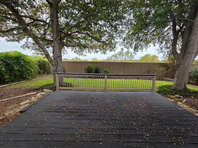a view of a tennis ground with a large trees
