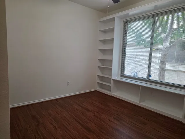 a view of a room with wooden floor and a window
