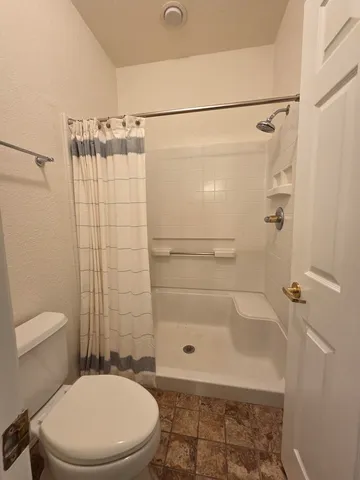 a bathroom with a toilet and a shower