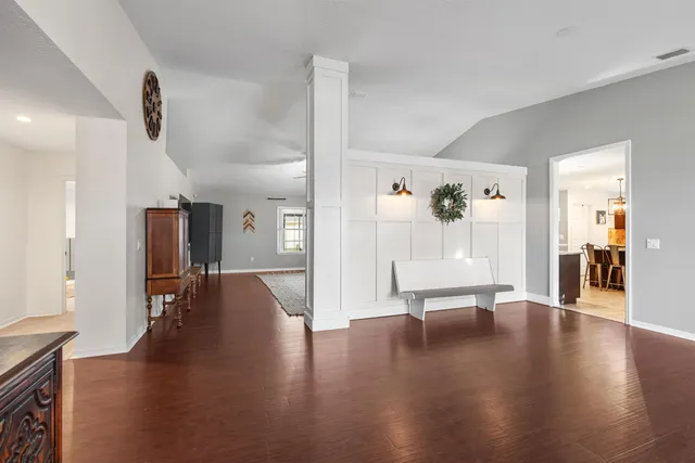 a hallway with wooden floor and furniture