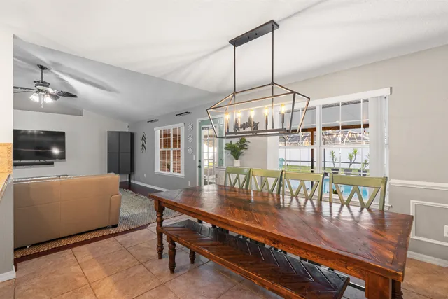 a dining room with furniture a chandelier and wooden floor