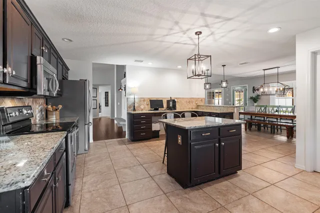 a large kitchen with stainless steel appliances granite countertop a stove oven and a sink