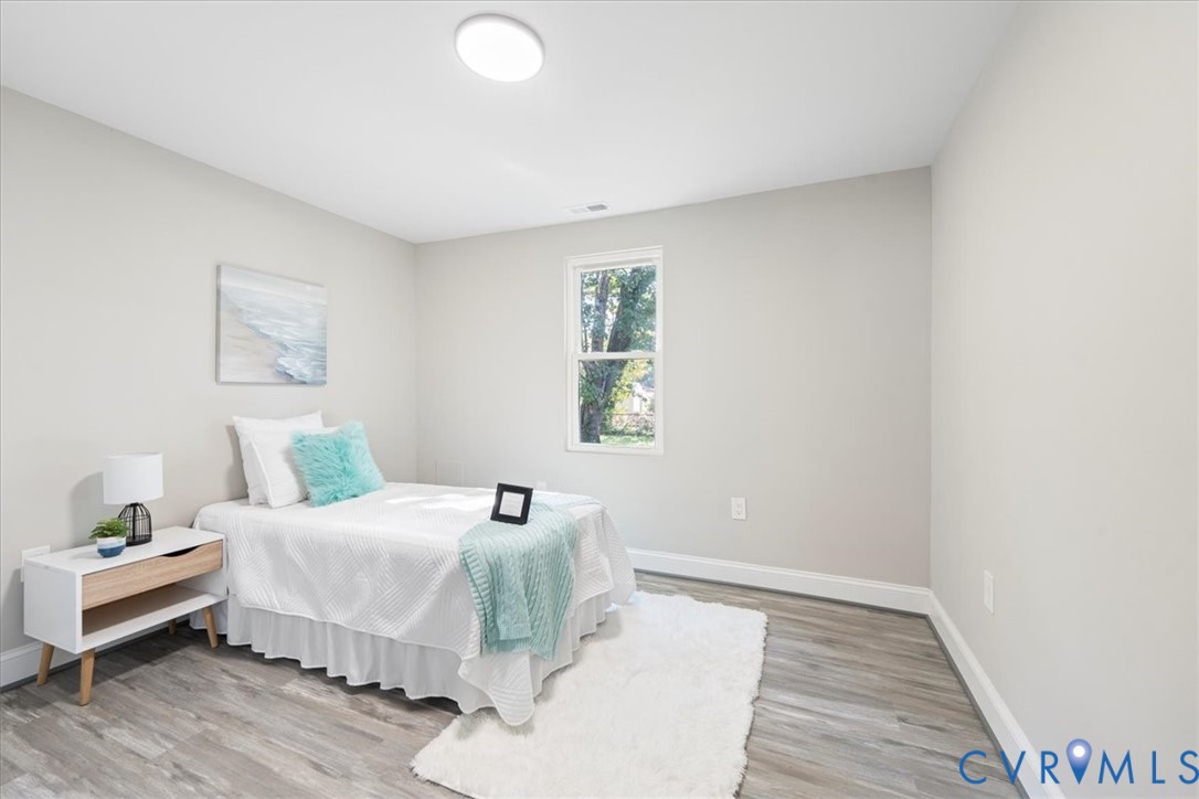 1701 Arlington Road Hopewell, VA 23860 - Photo 21 of 29 a bedroom with a bed and wooden floor