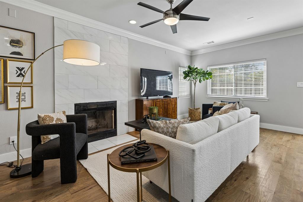 706 South Jupiter Road, Unit 307 Allen, TX 75002 - Photo 2 of 32 Recessed lighting, crown molding, a ceiling fan, and a fireplace with a tile surround