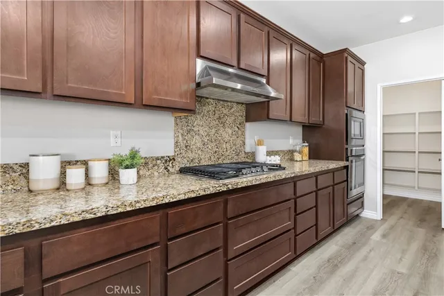 a kitchen with granite countertop wooden cabinets and a sink