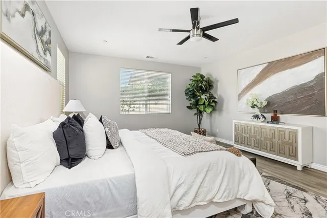 a bedroom with a bed a chandelier and a window