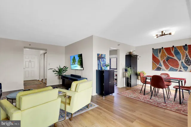 a living room with furniture a dining table and wooden floor