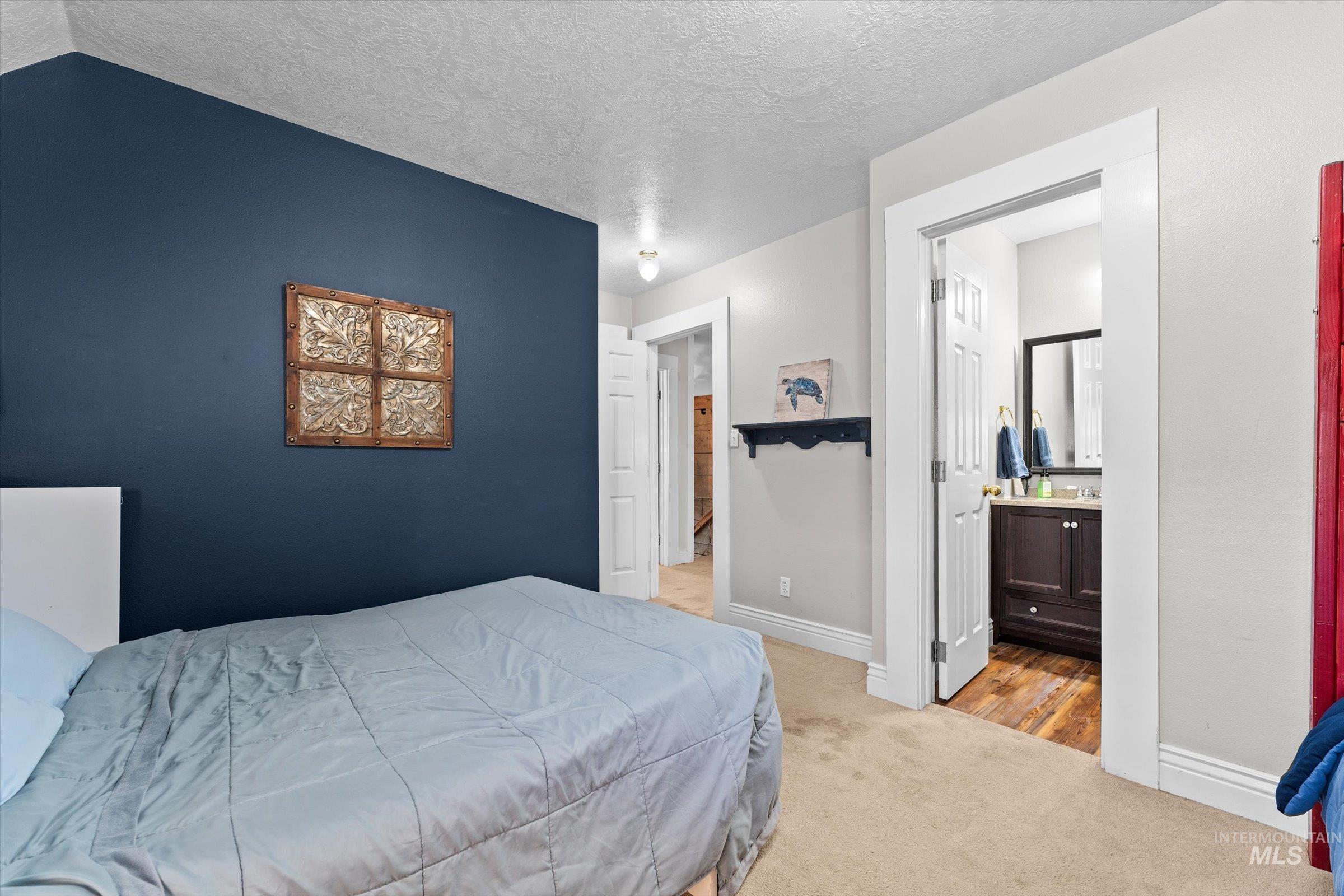 315 South Middlefork Road Garden Valley, ID 83622 - Photo 21 of 49 Bedroom with light carpet, a textured ceiling, and ensuite bath