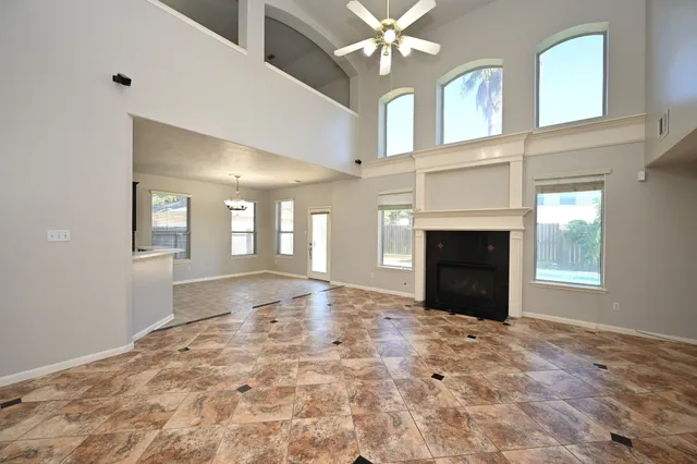 an empty room with windows and chandelier