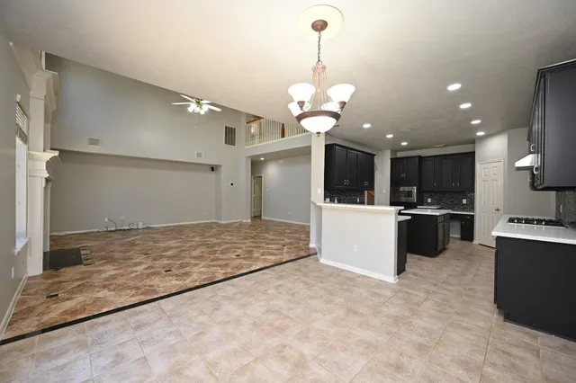 a kitchen with stainless steel appliances kitchen island granite countertop a stove a sink dishwasher and a refrigerator