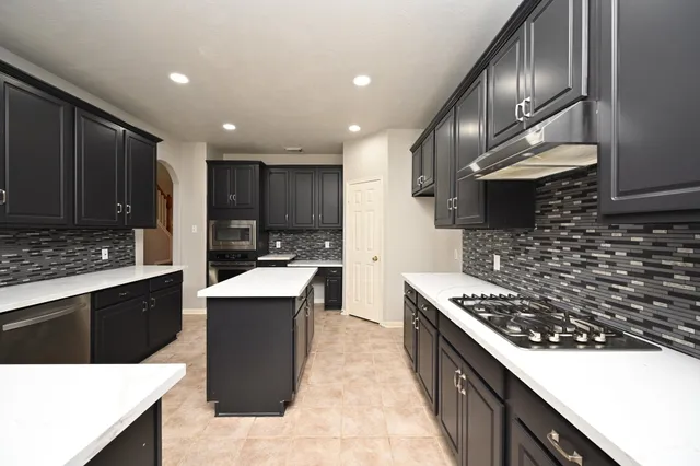 a kitchen with a sink stainless steel appliances and cabinets