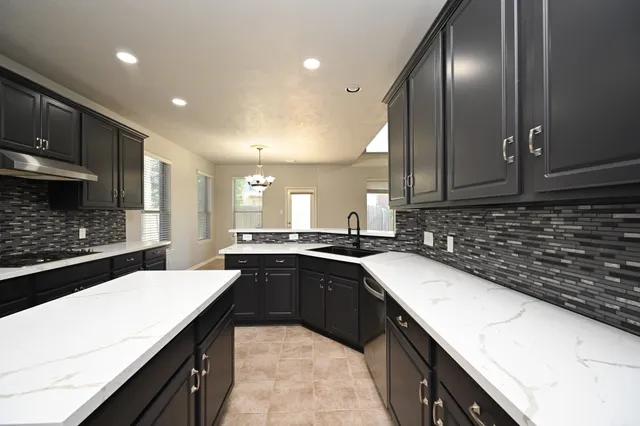 a large kitchen with stainless steel appliances granite countertop a stove a sink dishwasher and a refrigerator