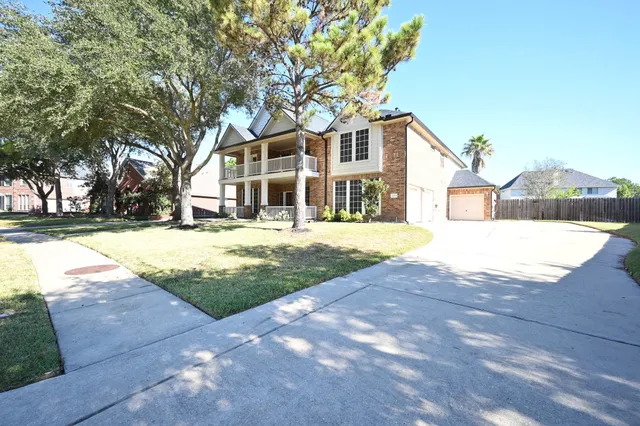 a front view of a house with a yard and trees
