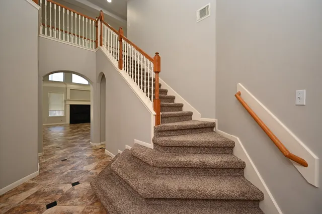 an empty room with windows and ceiling fan