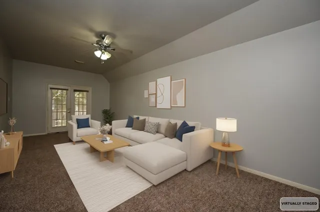 an empty room with a chandelier fan and windows