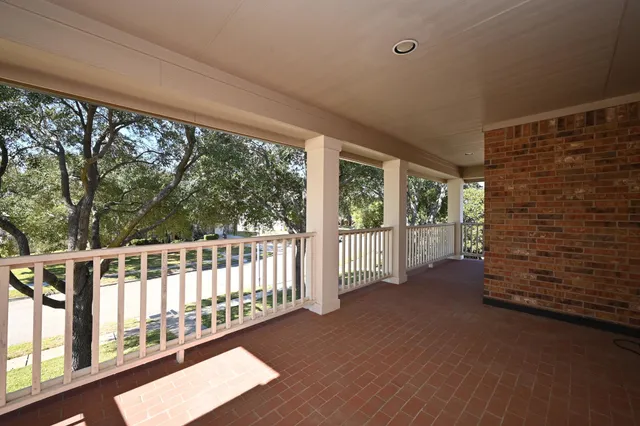 an empty room with windows and chandelier fan