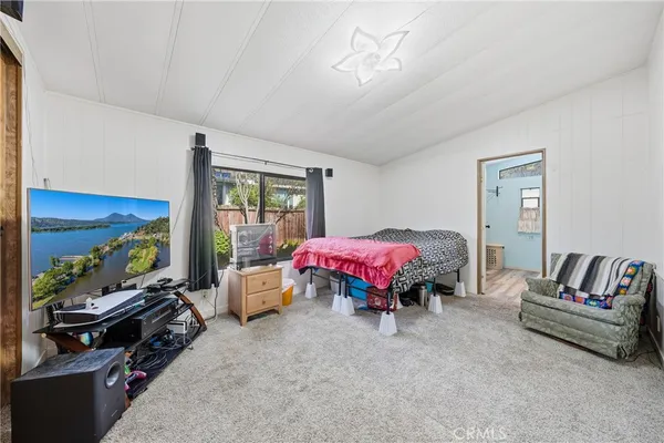 a bedroom with a bed and dresser with mirror