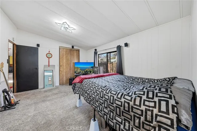 a bedroom with a bed a mirror and paintings on the wall