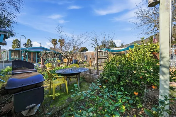 a view of a chairs and table in backyard