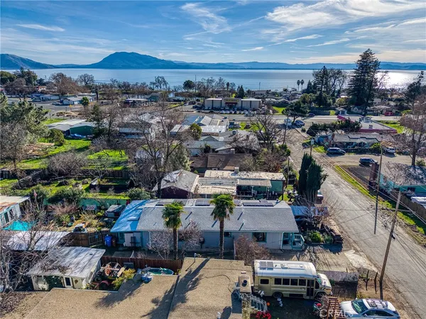 a view of wooden house with a yard and lawn chairs