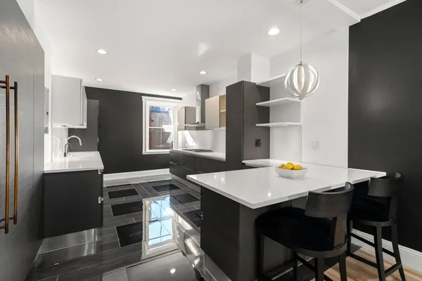 a kitchen with stainless steel appliances a stove a refrigerator and a dining table with wooden cabinet