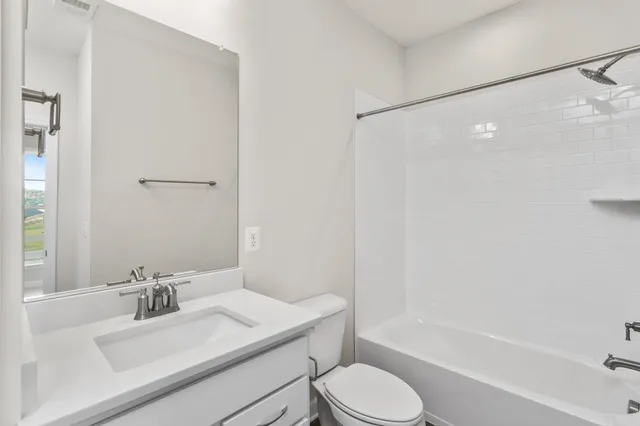 a bathroom with a sink toilet vanity and shower
