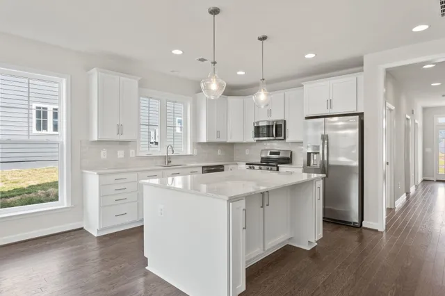 a kitchen with kitchen island a sink stainless steel appliances and cabinets