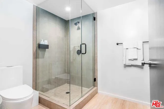 a bathroom with a shower a toilet and a sink