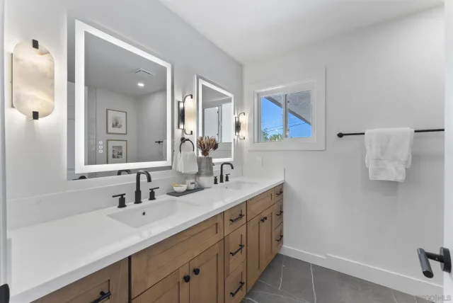 a bathroom with a double vanity sink and mirror