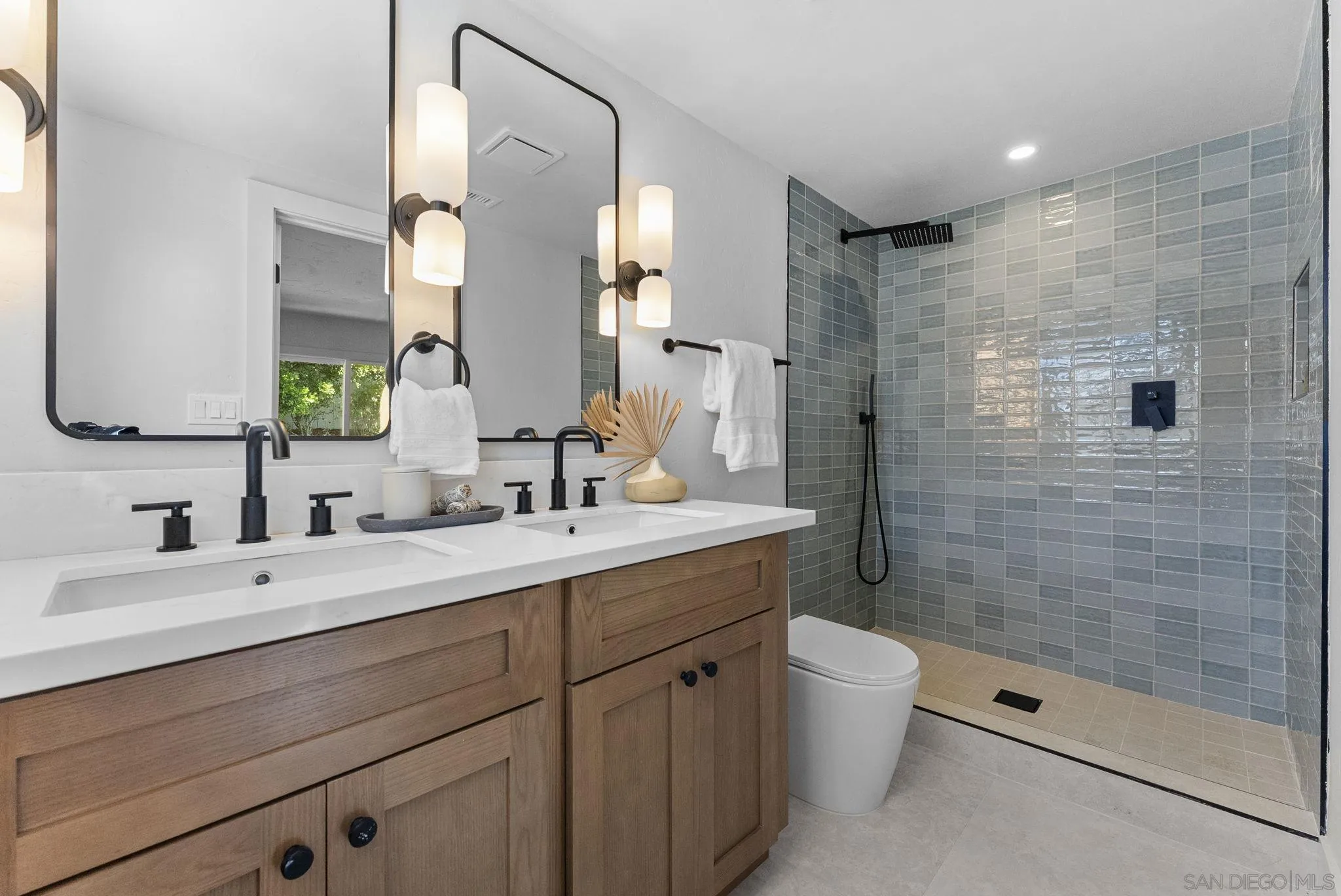 12830 Avenida La Valencia Poway, CA 92064 - Photo 30 of 47 a bathroom with a double vanity sink toilet mirror and shower