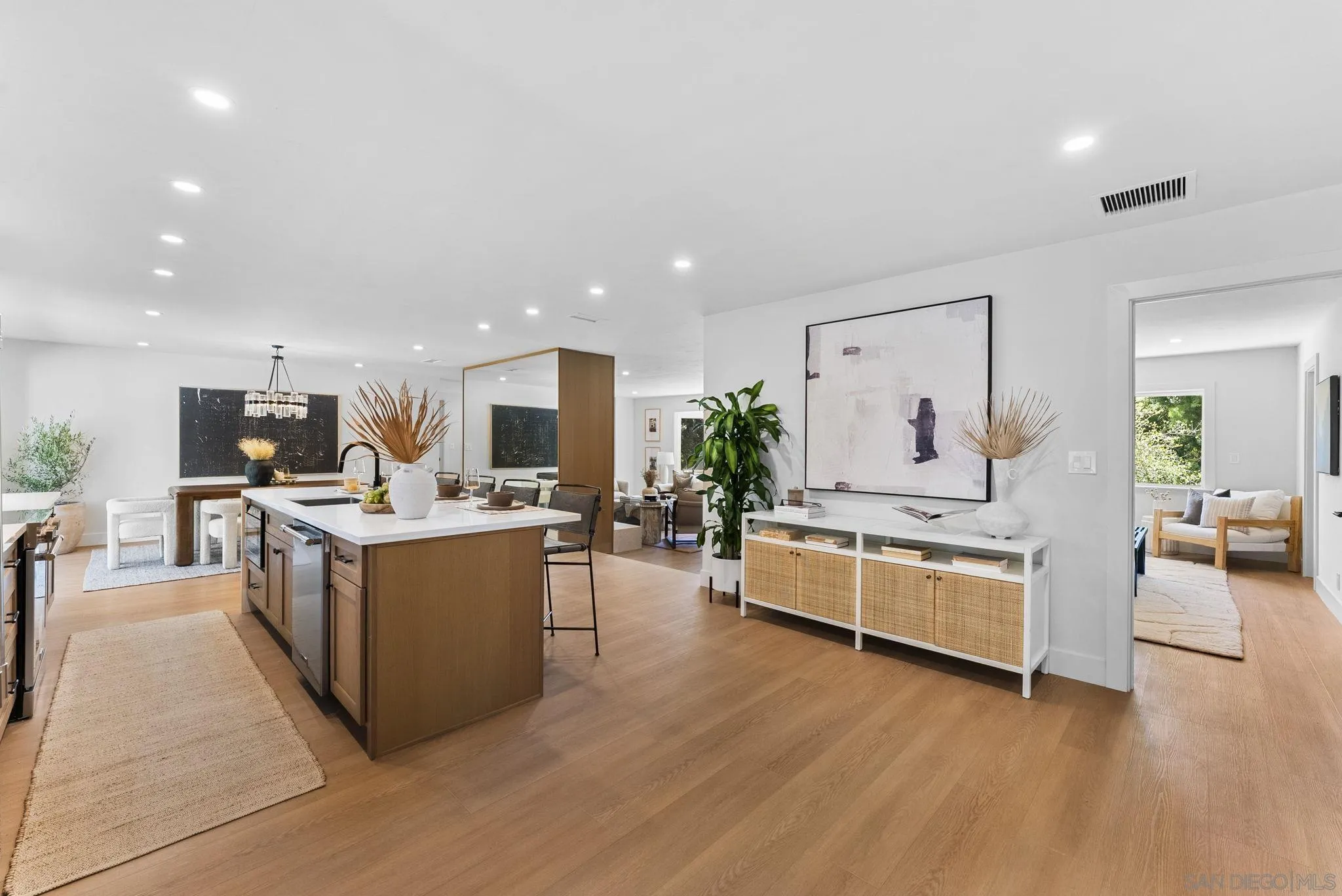 12830 Avenida La Valencia Poway, CA 92064 - Photo 9 of 47 a large living room with stainless steel appliances kitchen island a table chairs in it and a flat screen tv