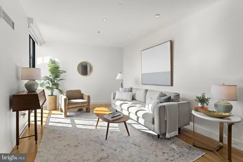 a living room with furniture wooden floor and a lamp