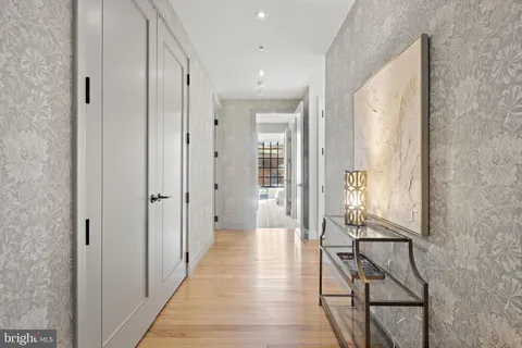 a view of a hallway with wooden floor and windows