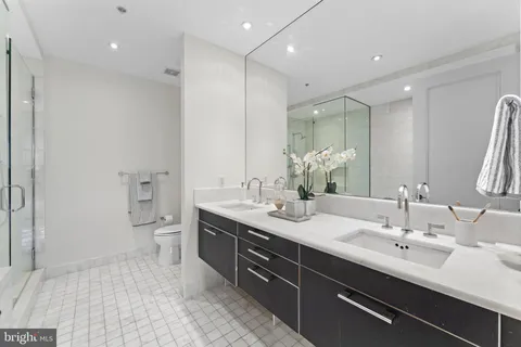 a bathroom with a double vanity sink mirror and toilet
