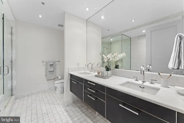 a bathroom with a double vanity sink mirror and toilet