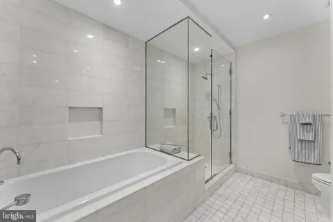 a bathroom with a bathtub a toilet and a shower