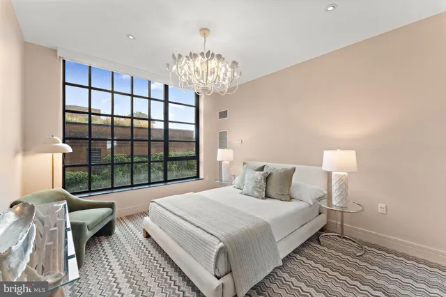 a bedroom with a large bed and a chandelier