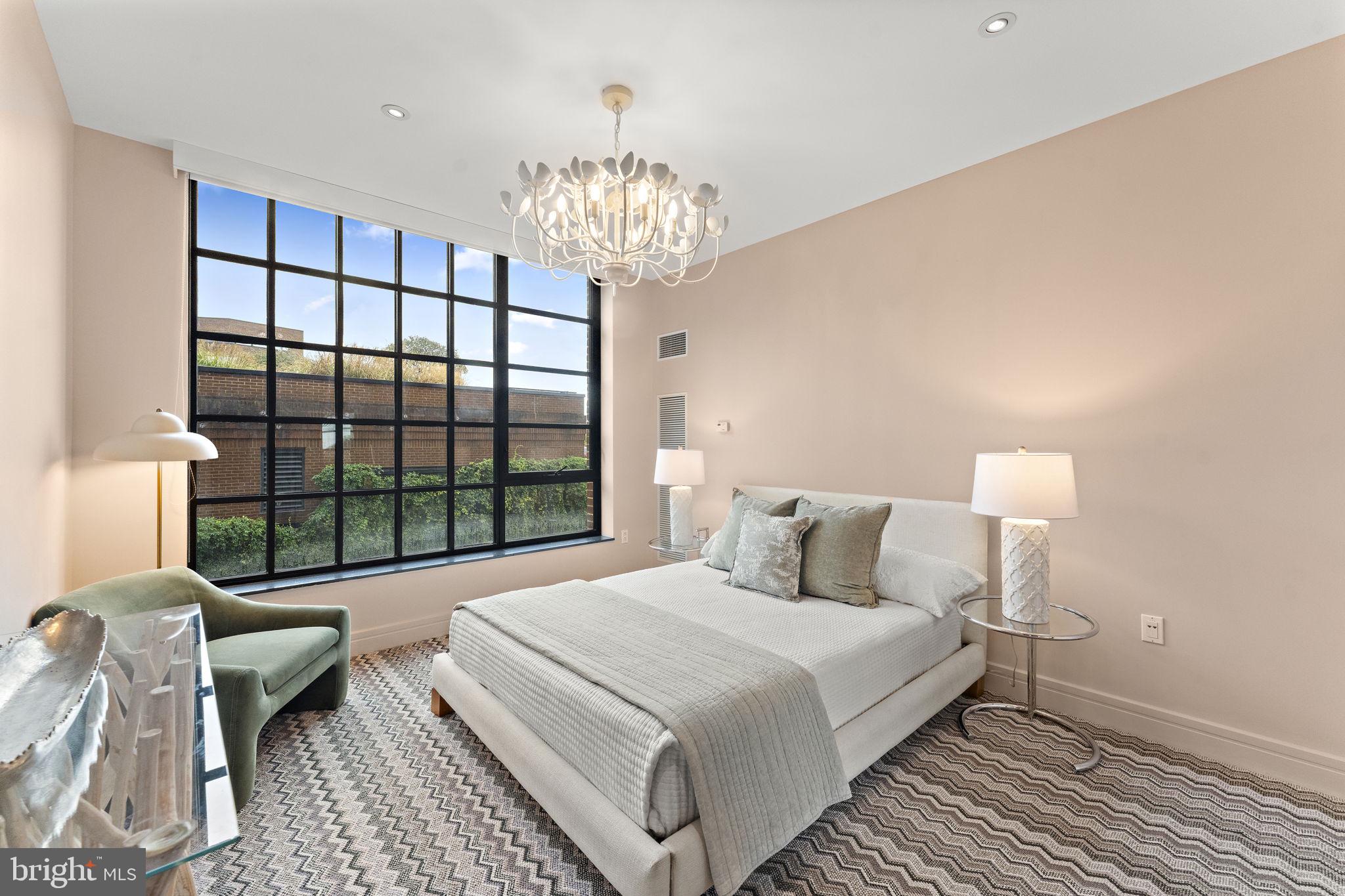 3303 Water Street Northwest, Unit 4L Washington, DC 20007 - Photo 25 of 60 a bedroom with a large bed and a chandelier