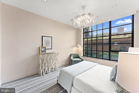 a bedroom with a large bed and a chandelier