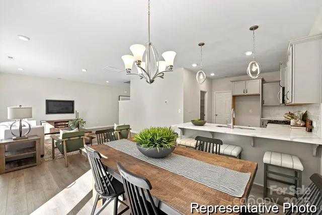 a dining room filled chandelier and kitchen view