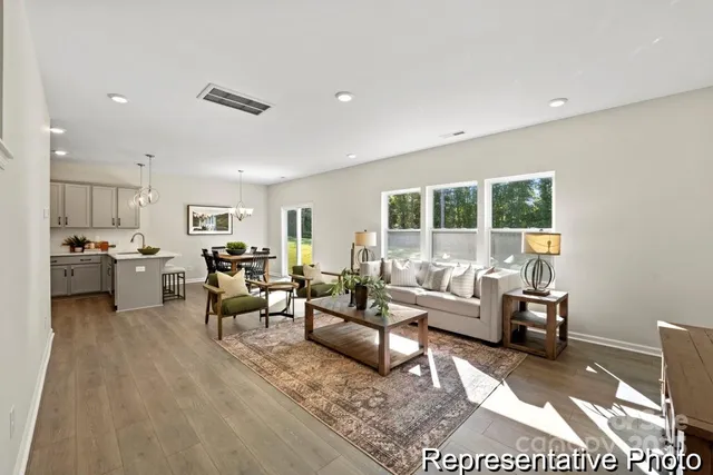a living room with furniture and view of kitchen