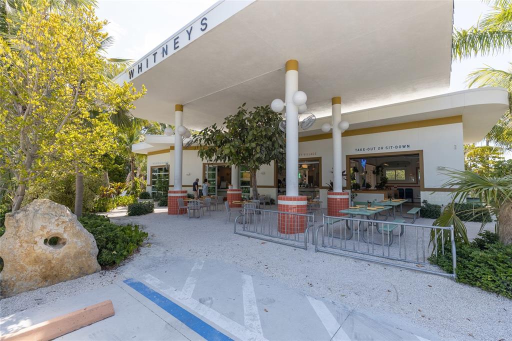 591 Russell Street Longboat Key, FL 34228 - Photo 18 of 19 a view of a patio with table and chairs potted plants and a large tree