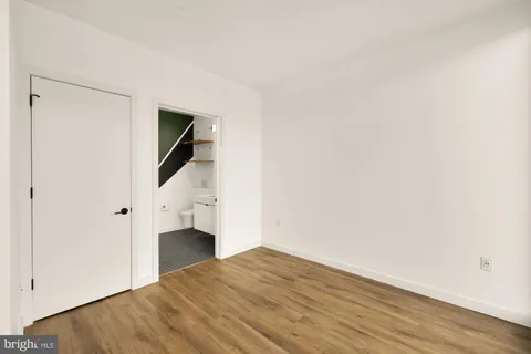 a view of a livingroom with wooden floor and staircase