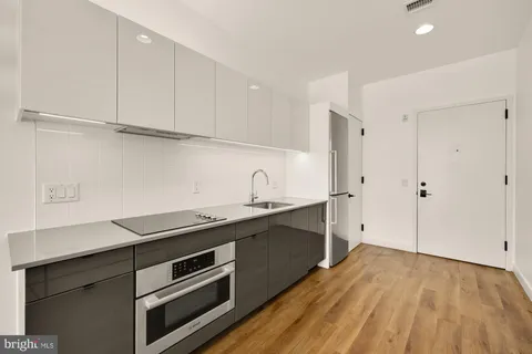 a kitchen with stainless steel appliances a sink stove and cabinets