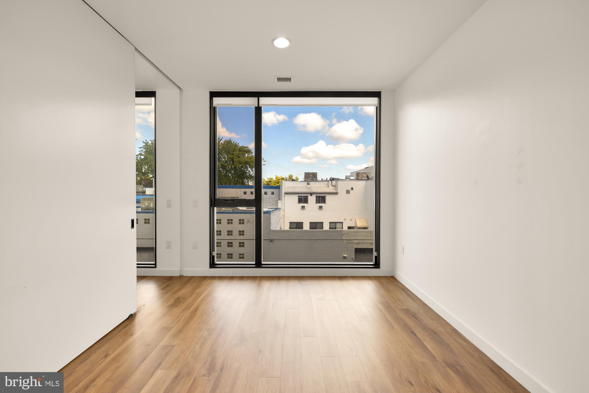 57 N Street Northwest, Unit 331 Washington, DC 20001 - Photo 10 of 26 an empty room with wooden floor and windows