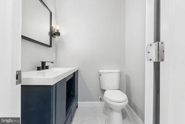 a bathroom with a sink a toilet and a mirror