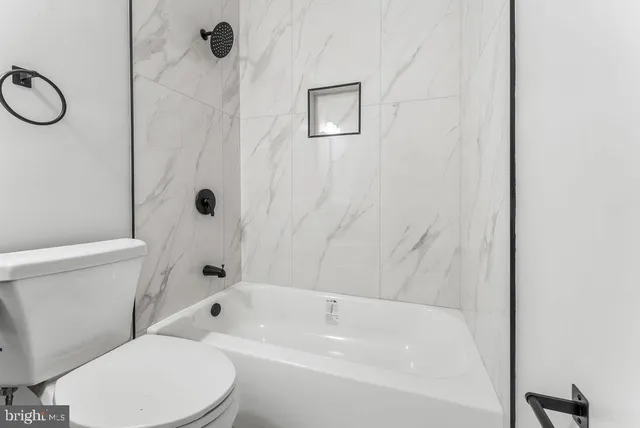 a bathroom with a toilet and a tub