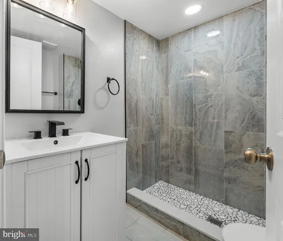 a bathroom with a shower sink and mirror
